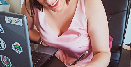 Mujer sentada frente a escritorio y escribiendo en libretada. Cely Cruz. Wola te cuenta. Somos Wola.