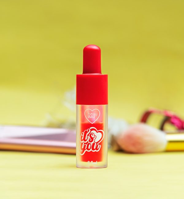 Labial tipo tinte puesto sobre fondo amarillo y cosmeticos de fondo. Foto by Cely Cruz para Vibra Creativa.