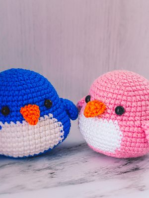 2 pinguinos enamorados, hechos de lana. Sobre fondo blanco. Foto para artículo Kathes Crochet para Vibra Creativa by Cely Cruz
