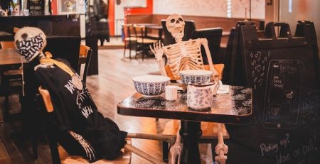 Esqueletos sentados a la mesa. Decoración de halloween. Lleva la tendencia de Halloween a tu restaurante y vende más